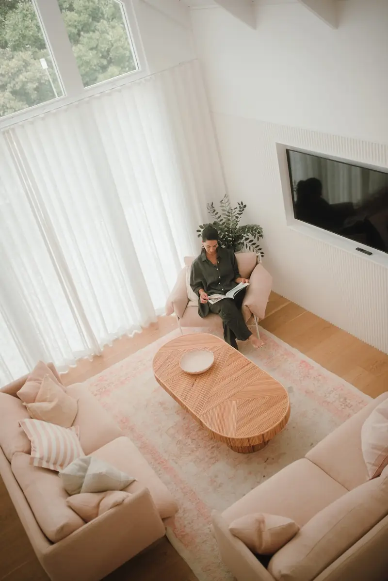 Bright, organised Gold Coast living room with neutral sofas and a clear coffee table